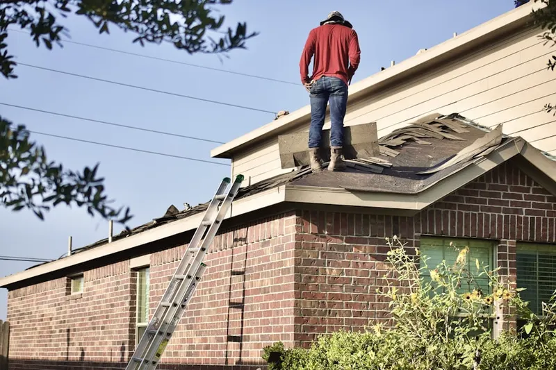 Professional roofer working on a residential roof in Blossvale